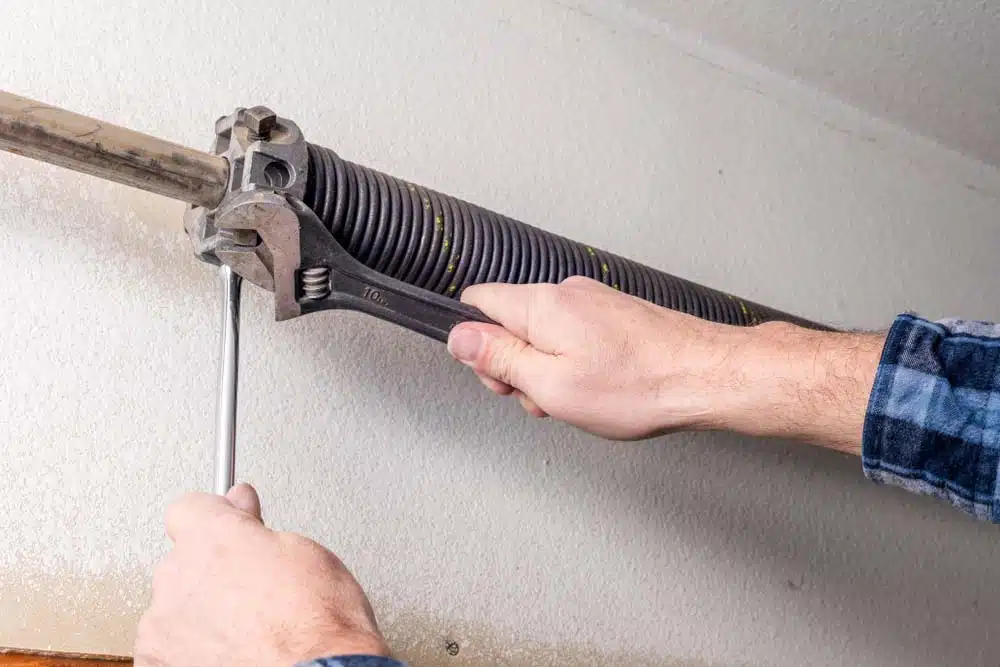 Person fixing garage door spring