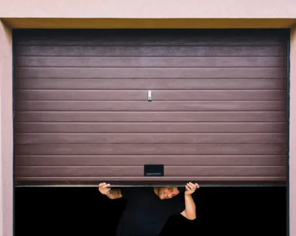 a man lifting the garage door