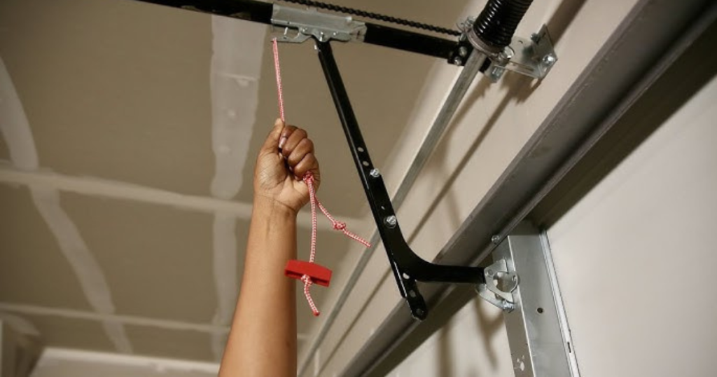 Hand pulling garage emergency release cord.