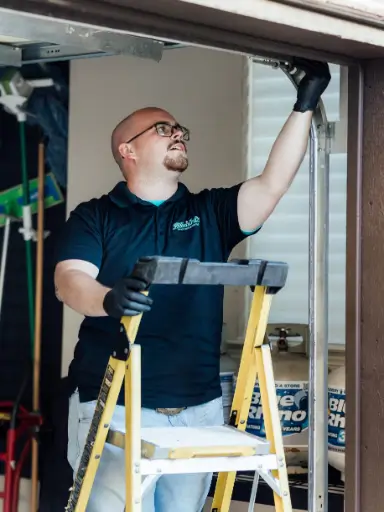repairman from meadows garage doors fixing spring for garage door