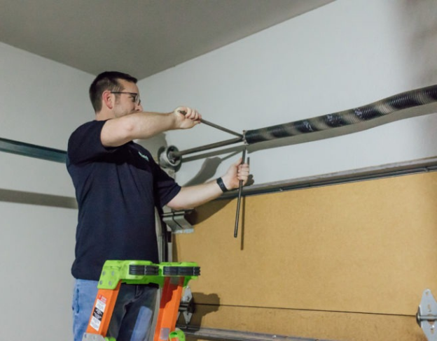 Team member fixing garage door springs