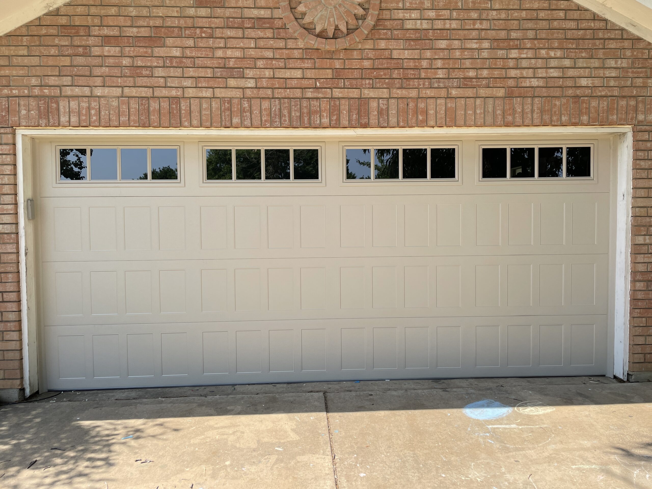Off-white carriage style residential garage door with windows.
