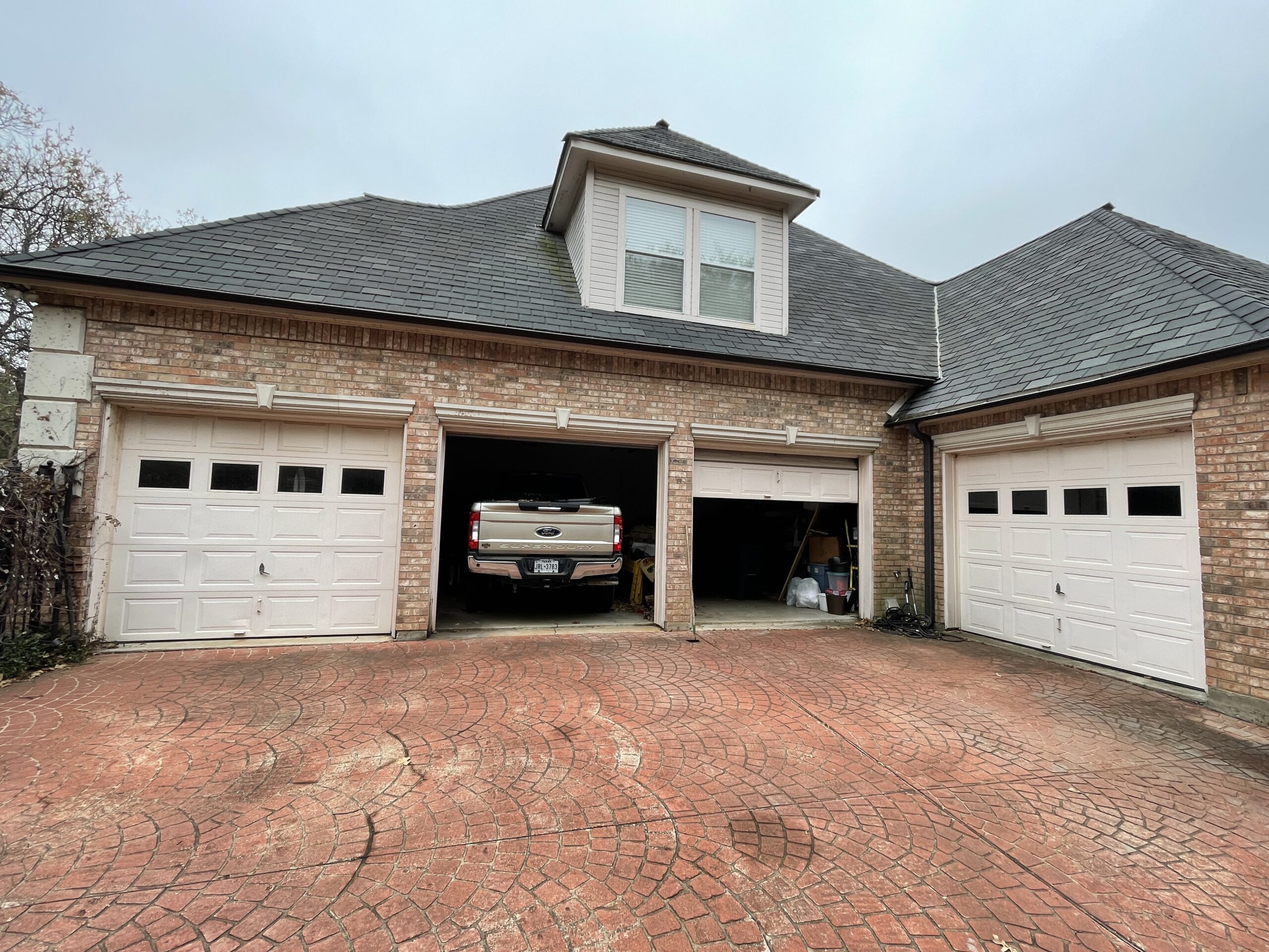 Four car windowed residential garage. Two of the doors are open.