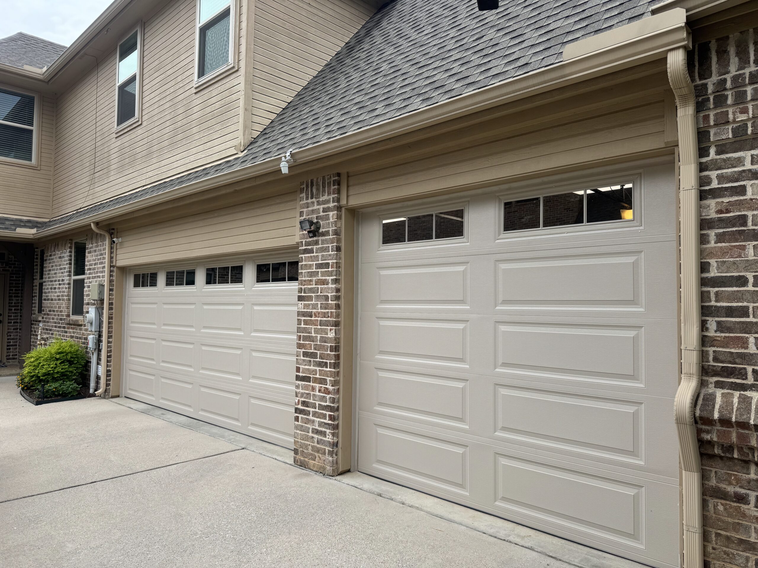 Two door, three car residential carriage style white garage doors.