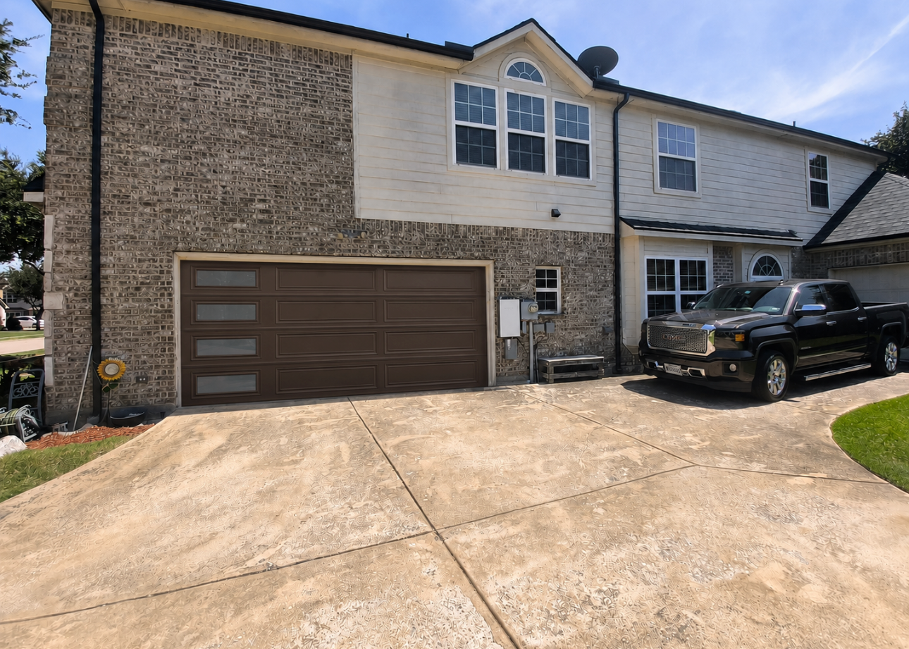 Two car residential wood tone garage door with windows.